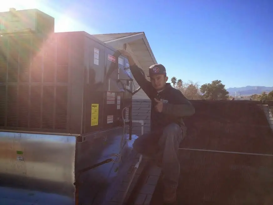 HVAC technician performing Air Duct Cleaning on a rooftop unit in Germantown