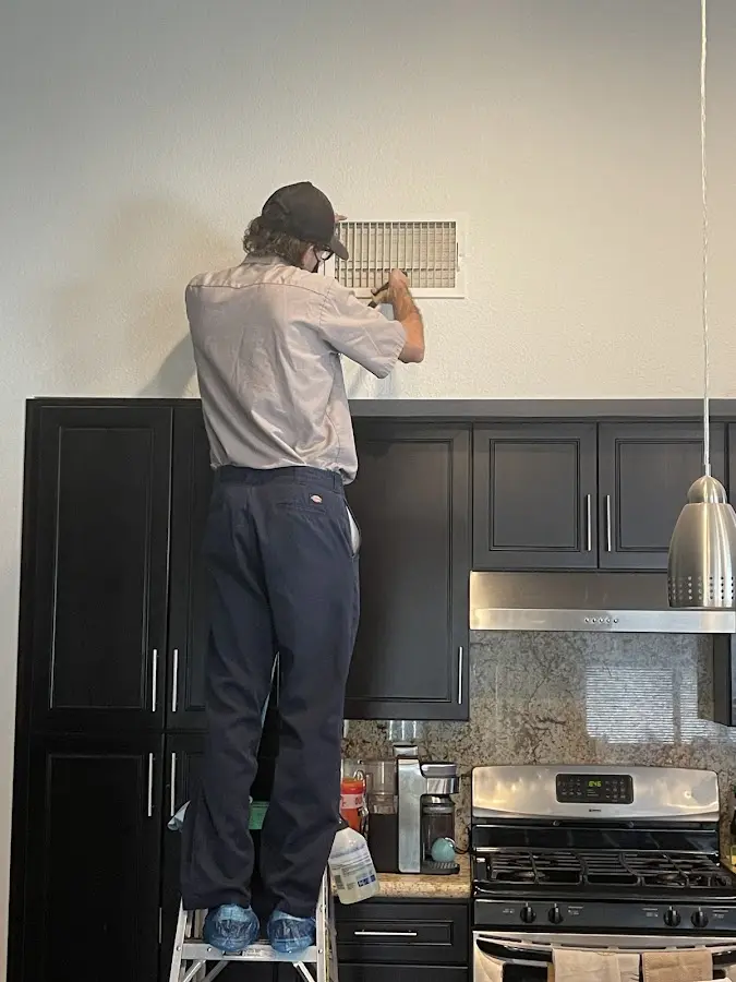 Technician inspecting an air vent during HVAC service in Germantown